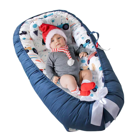 bebe en detente dans son reducteur de lit bleu
